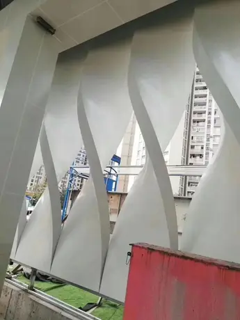 Clôture en aluminium perforée protégeant un panneau peint PPG